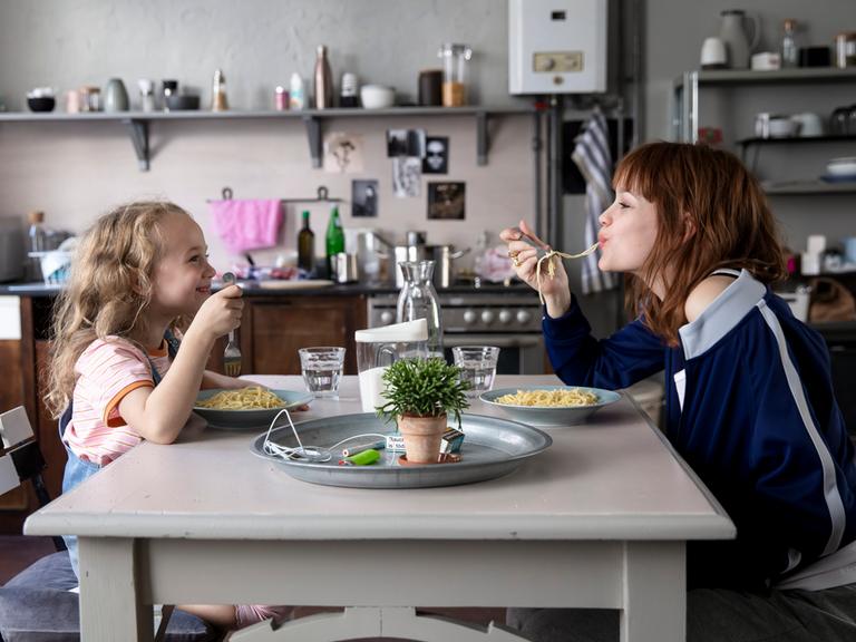 Szene aus dem Film "Wunderschön". Rechts im Bild Karoline Herfurth als Mutter Sonja, links ihre Filmtochter. Beide essen Spaghetti. 