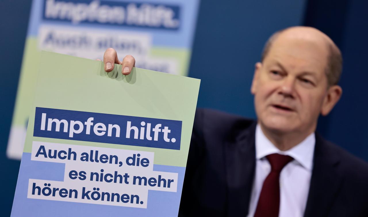 Bundeskanzler Olaf Scholz (SPD) präsentiert ein Plakat für eine neue Impfkampagne während einer Pressekonferenz nach einem Treffen im Kanzleramt.