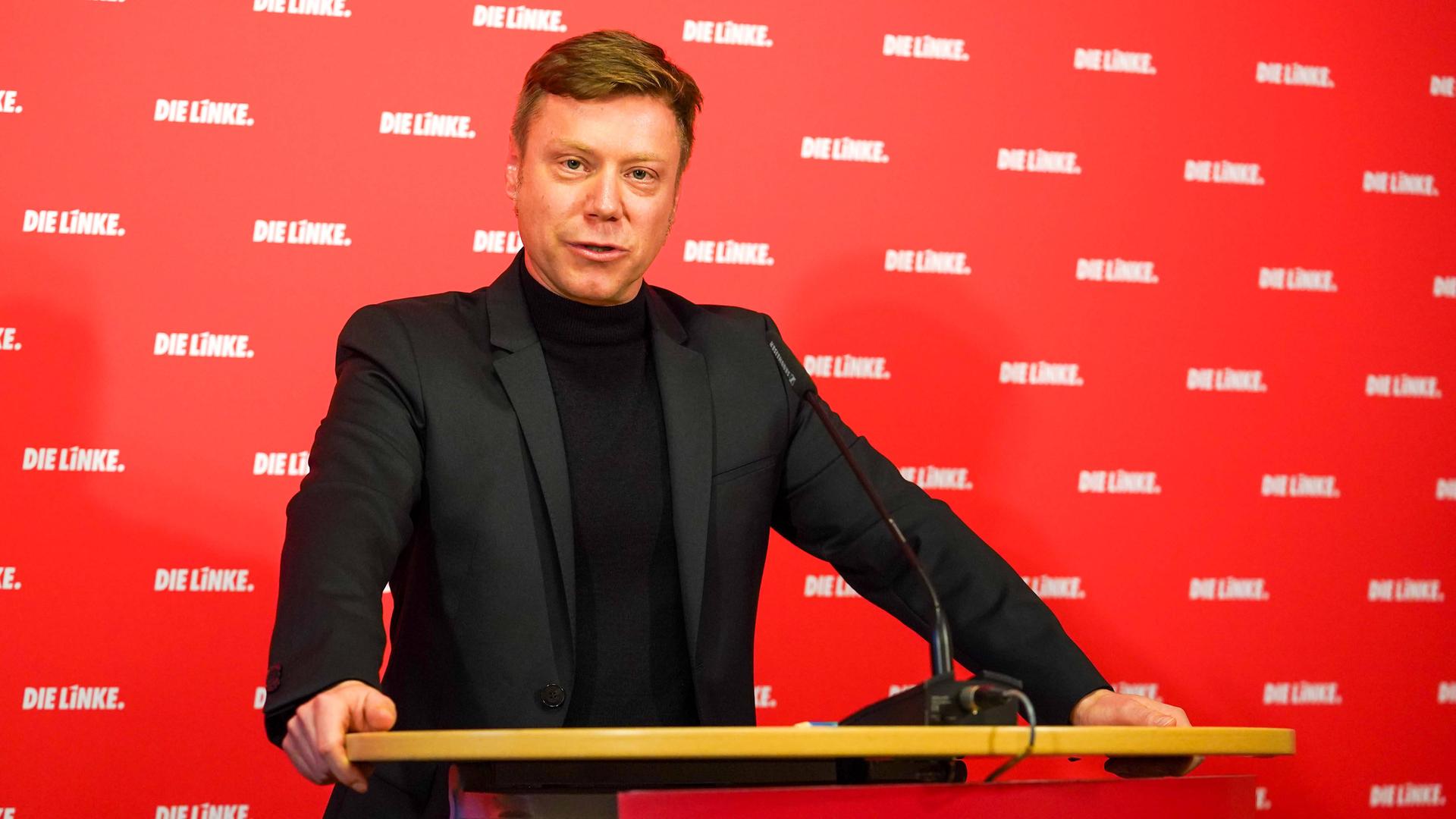 Martin Schirdewan, Co-Vorsitzender der Linken, steht vor einer roten Tapete mit weißem "Linke" Aufdruck hinter einem Rednerpult.