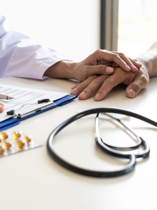 Ein Arzt und ein Patient sitzen an einem Tisch (Symbolfoto)