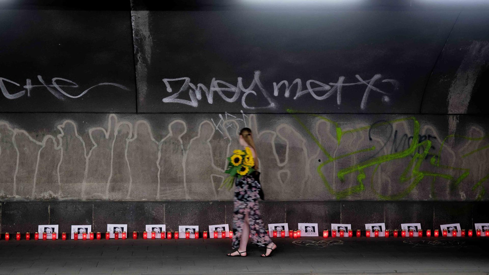 Kerzen und Karten mit den Namen der 21 Opfer stehen am 10. Jahrestag der Loveparade-Katastrophe in einem Tunnel, der zum Ort der Katastrophe führt. Bei der Loveparade am 24. Juli 2010 starben am einzigen Zu- und Abgang zum Veranstaltungsgelände in einem Gedränge 21 junge Menschen.