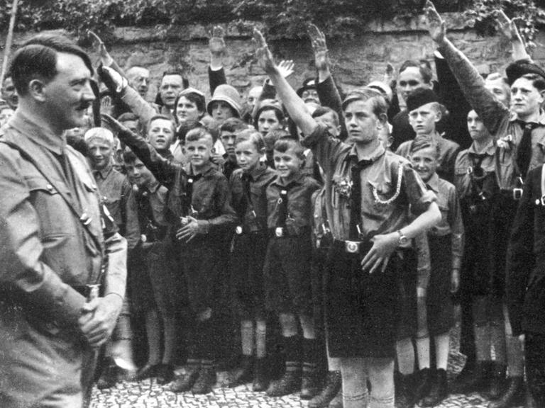 Adolf Hitler besucht die the Hitler-Jugend in Erfurt, die ihn salutierend empfängt.