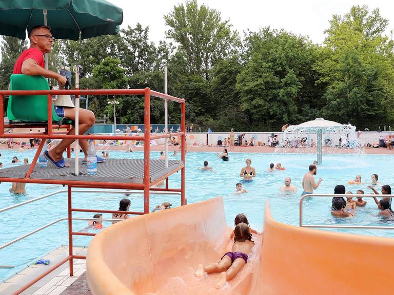 Freibad, orangefarbene Rutsche, Bademeister, Wasserpilz. Sommerbad Kreuzberg, Prinzenbad in Berlin.