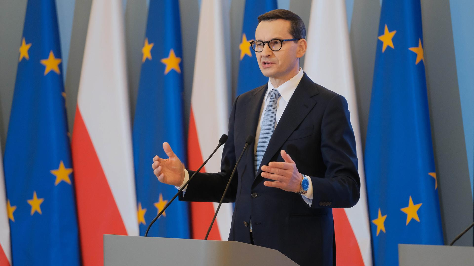 Morawiecki steht an einem Rednerpult vor polnischen und europäischen Fahnen.