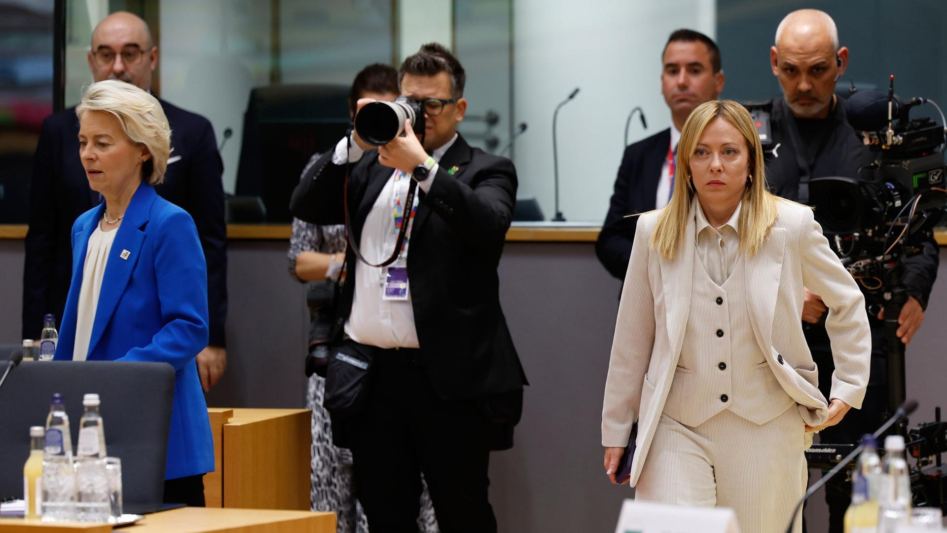 Die Präsidentin der Europäischen Kommission, Ursula von der Leyen (links), und die italienische Ministerpräsidentin Giorgia Meloni beim EU-Gipfel in Brüssel. In der Mitte des Bilds steht ein Fotograf. 