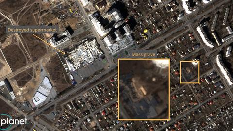 Ein Massengrab neben einer Kirche und ein zerstörter Supermarkt in Butscha in der Ukraine, aufgenommen am 21. März 2022 durch Satelliten des Unternehmens Planet. 