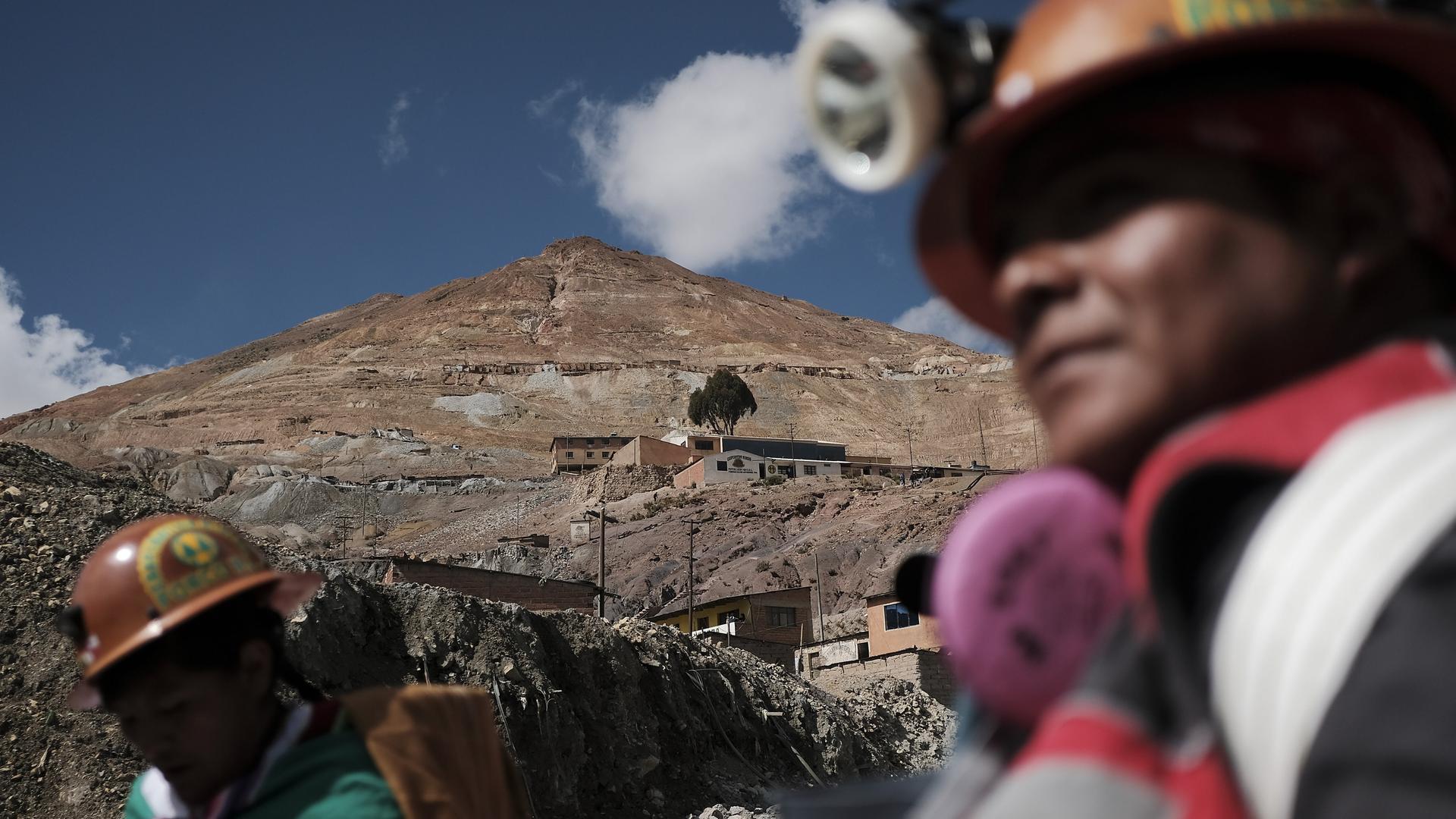 Der Hauptberg der Minen Cerro Rico (Rich Hill) während des Bergmannskarnevals in Potosi, Bolivien. Vorne sind unscharf Minenarbeiter zu sehen.