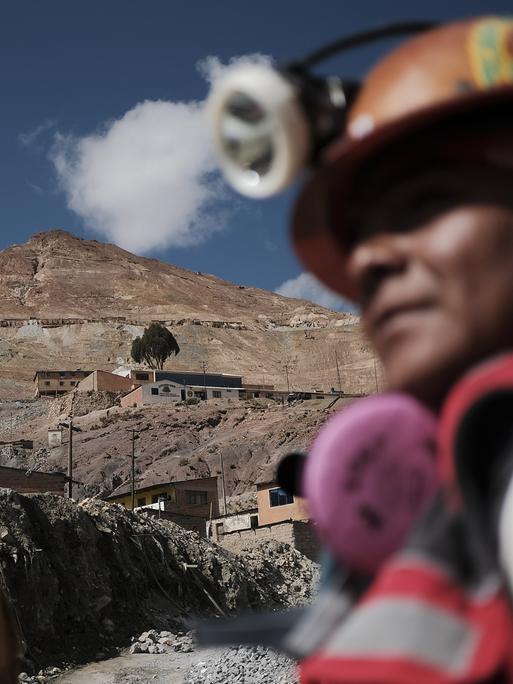Der Hauptberg der Minen Cerro Rico (Rich Hill) während des Bergmannskarnevals in Potosi, Bolivien. Vorne sind unscharf Minenarbeiter zu sehen.
