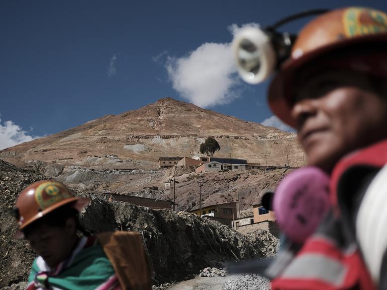 Der Hauptberg der Minen Cerro Rico (Rich Hill) während des Bergmannskarnevals in Potosi, Bolivien. Vorne sind unscharf Minenarbeiter zu sehen.