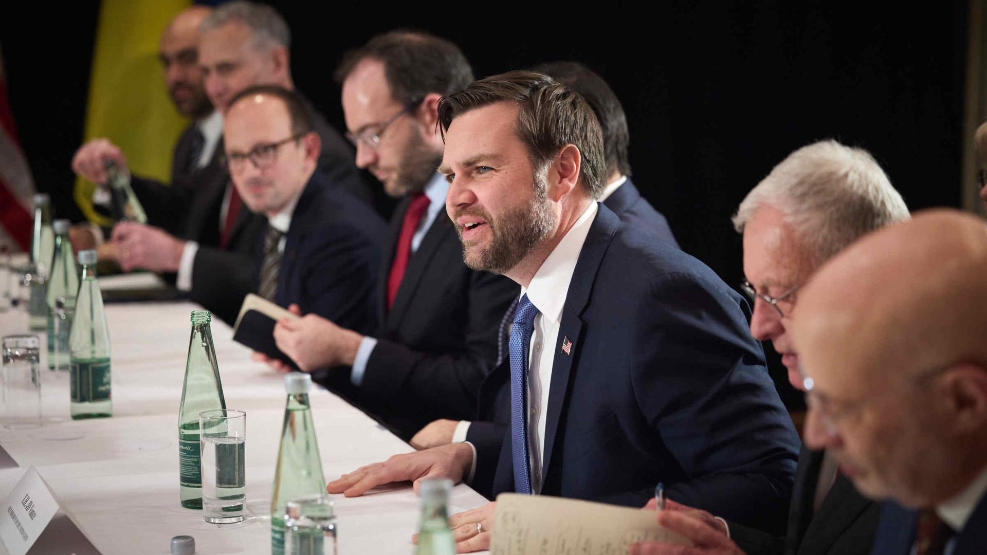 J.D. Vance (Vize Praesident USA) sitzt mit anderen internationalen am Tisch bei der Münchner Sicherheitskonferenz (MSC) 2025 am 15.02.2025 im Hotel Bayerischer Hof und spricht gestikulierend.