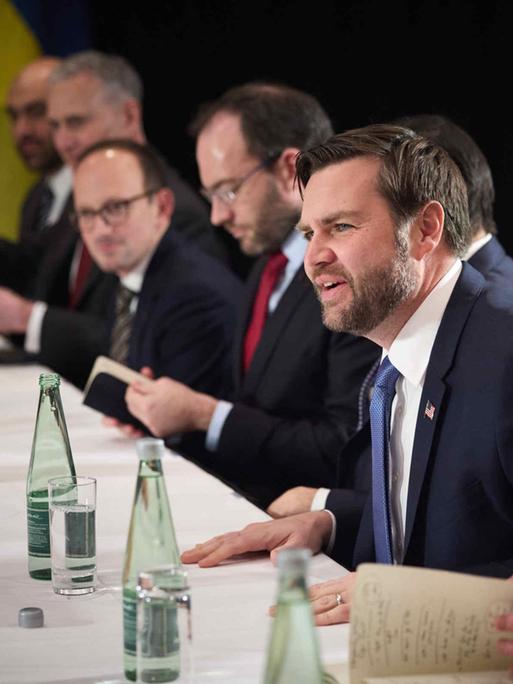 J.D. Vance (Vize Praesident USA) sitzt mit anderen internationalen am Tisch bei der Münchner Sicherheitskonferenz (MSC) 2025 am 15.02.2025 im Hotel Bayerischer Hof und spricht gestikulierend.