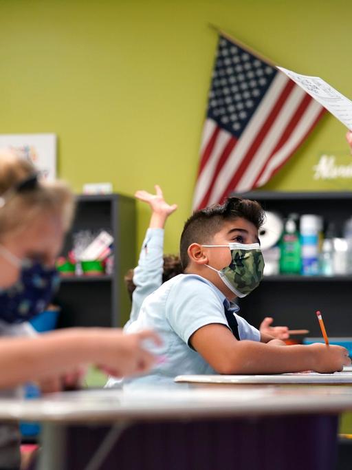 Kinder in einer Grundschule in Florida. Im Hintergrund die amerikanische Flagge.