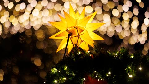 Deko-Stern und Lichterketten auf dem Weihnachtsmarkt am Dom in Köln 