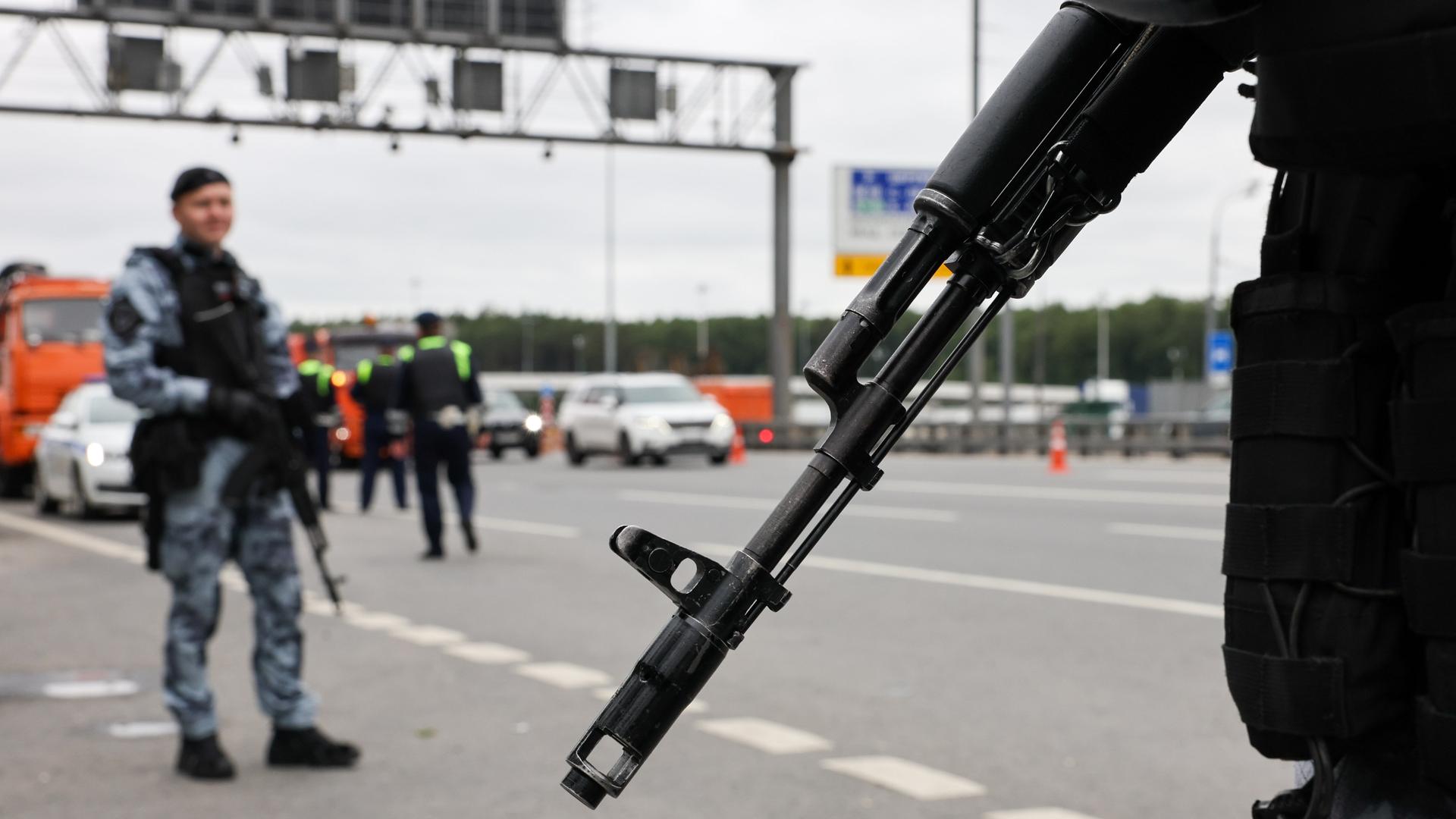 Russische Militärangehörige sichern bewaffnet eine Autobahn