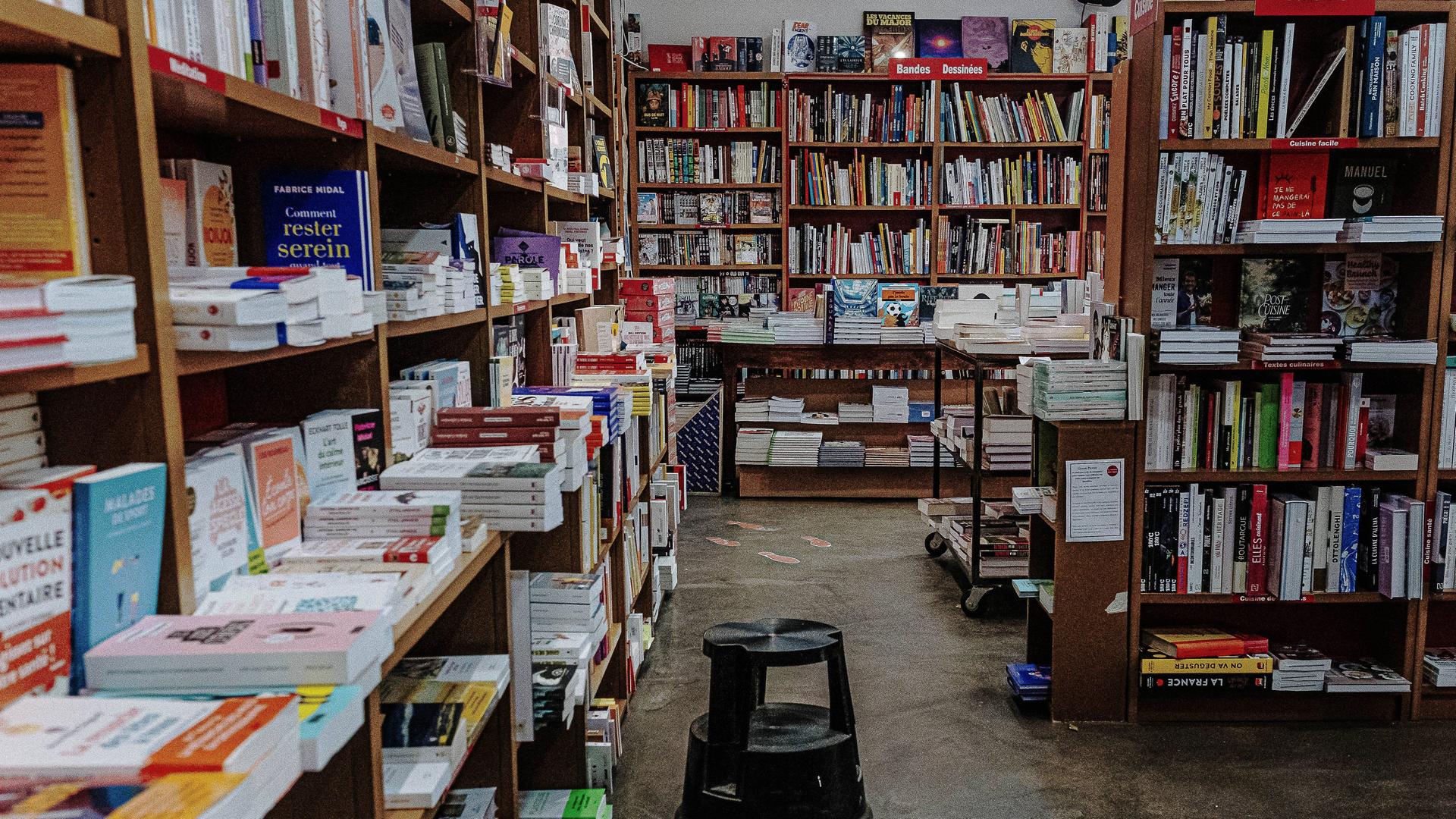 Innenansicht einer Buchhandlung in Frankreich. Man sieht Regale und Tische voller Bücher. Innenansicht einer Buchhandlung in Frankreich. Man sieht Regale und Tische voller Bücher.