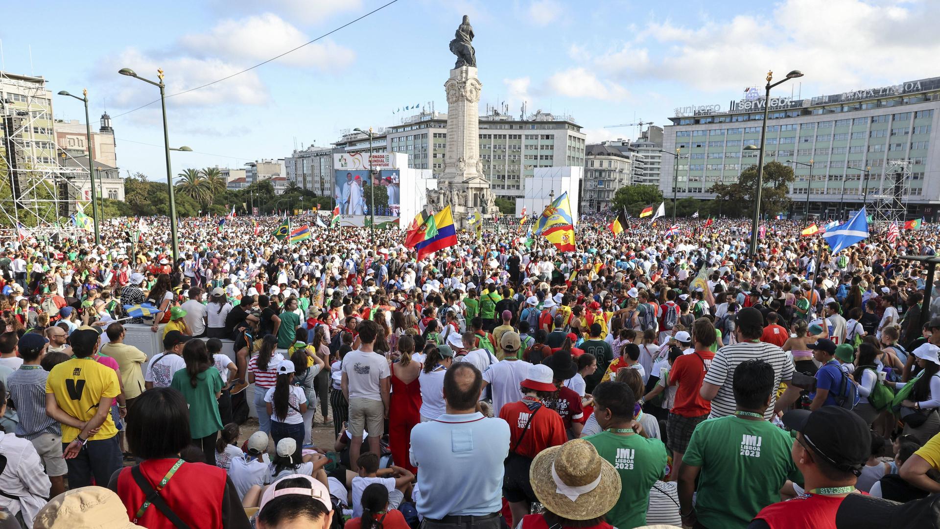 Das Foto zeigt viele Menschen auf einem Platz in der Stadt Lissabon. 