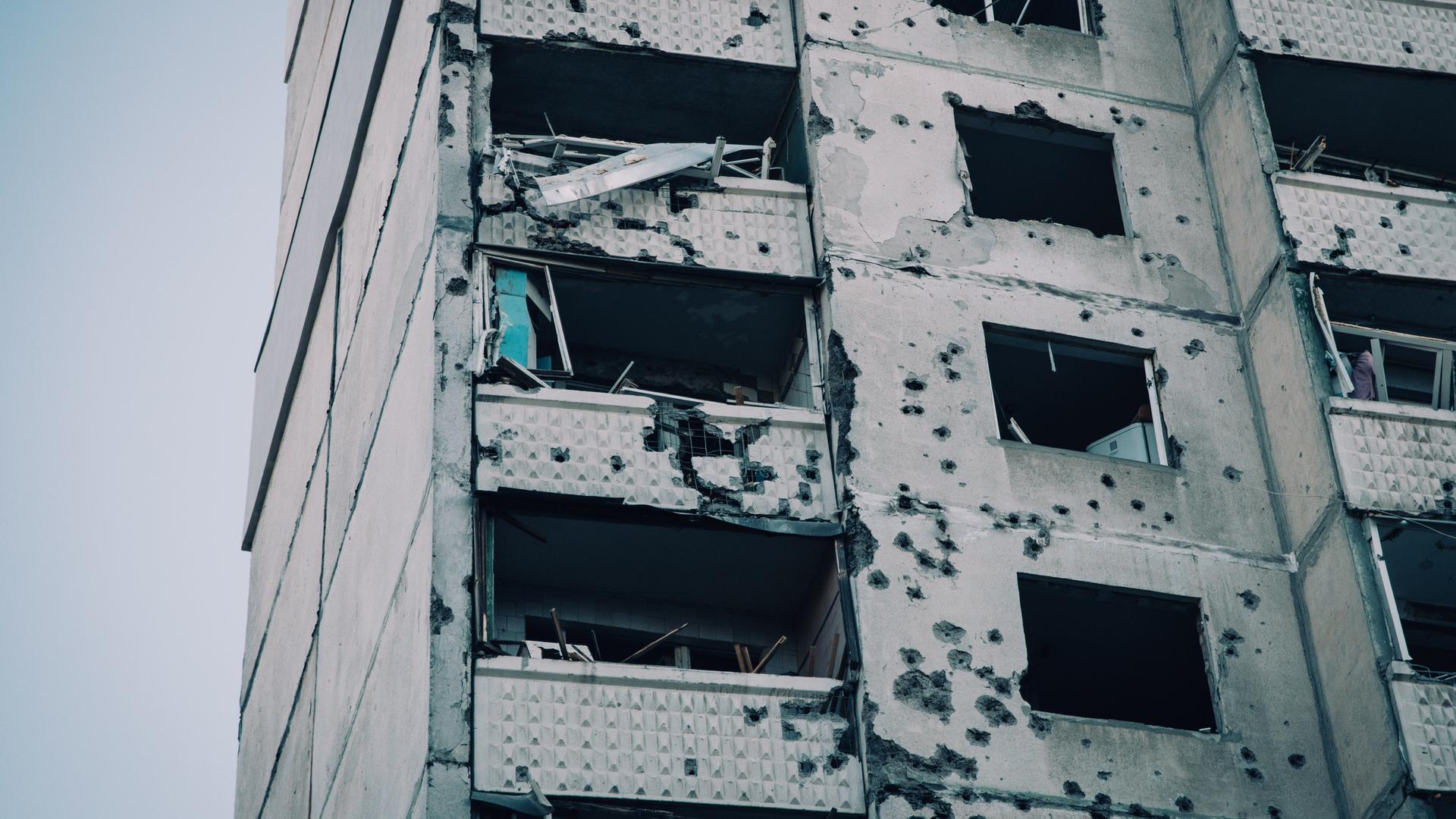 Beschädigte Fassade eines getroffenen Wohnkomplexes mit Schule und Kindergarten nach einem Luftangriff auf Charkiw in der Ukraine