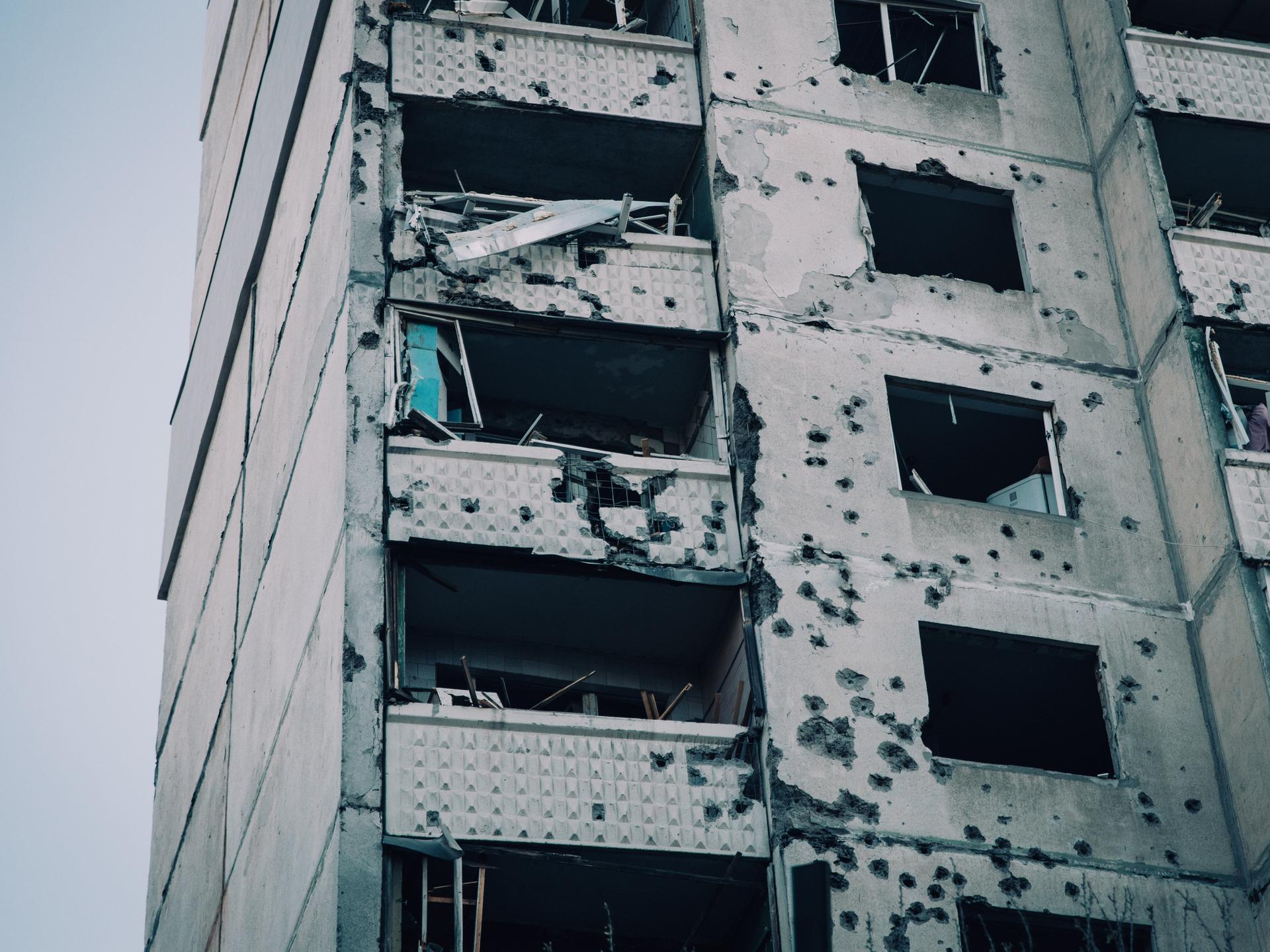 Beschädigte Fassade eines getroffenen Wohnkomplexes mit Schule und Kindergarten nach einem Luftangriff auf Charkiw in der Ukraine