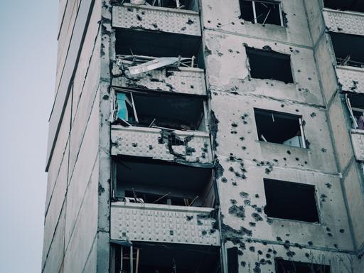 Beschädigte Fassade eines getroffenen Wohnkomplexes mit Schule und Kindergarten nach einem Luftangriff auf Charkiw in der Ukraine