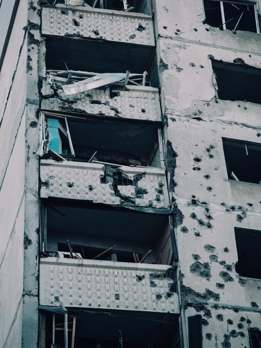 Beschädigte Fassade eines getroffenen Wohnkomplexes mit Schule und Kindergarten nach einem Luftangriff auf Charkiw in der Ukraine