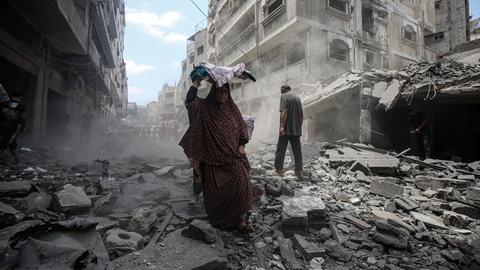 Eine Frau läuft im Gaza-Streifen durch die Trümmer eines durch einen israelischen Luftschlag zerstörten Gebäudes. 
