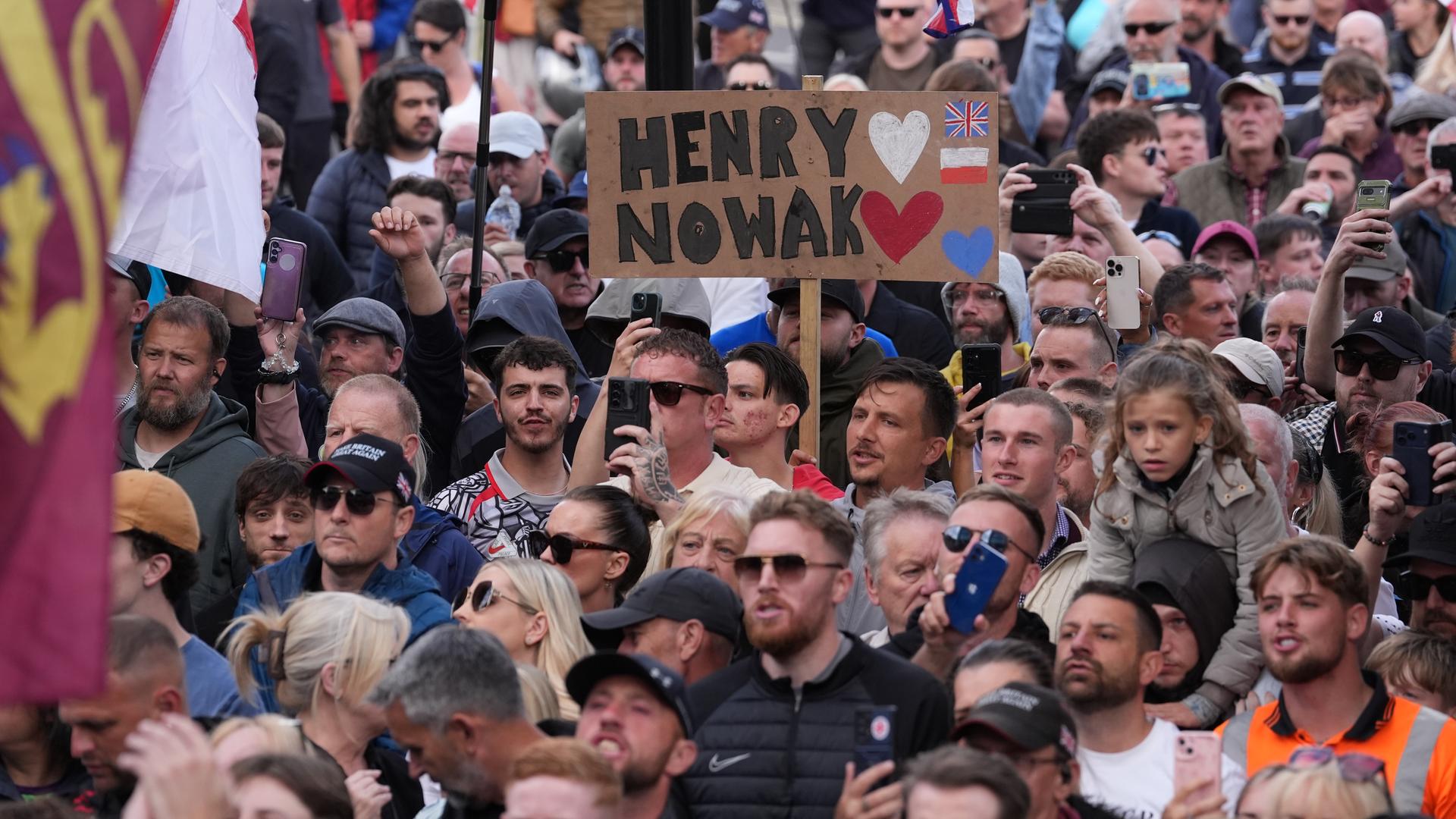 Viele Menschen protestieren vor der Polizeiwache in Southampton. Ein Plakat mit dem Namen "Henry Nowak" wird von einem Mann hochgehalten. 