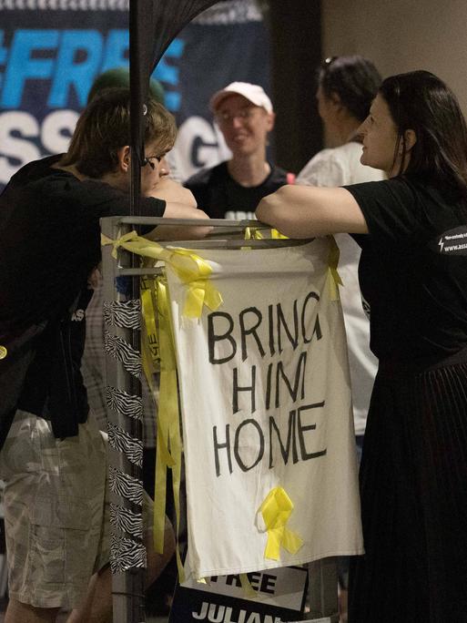 Demonstranten fordern die Rückkehr von Julian Assange nach Australien. Auf dem Schild steht "Bring ihn nach Hause". 