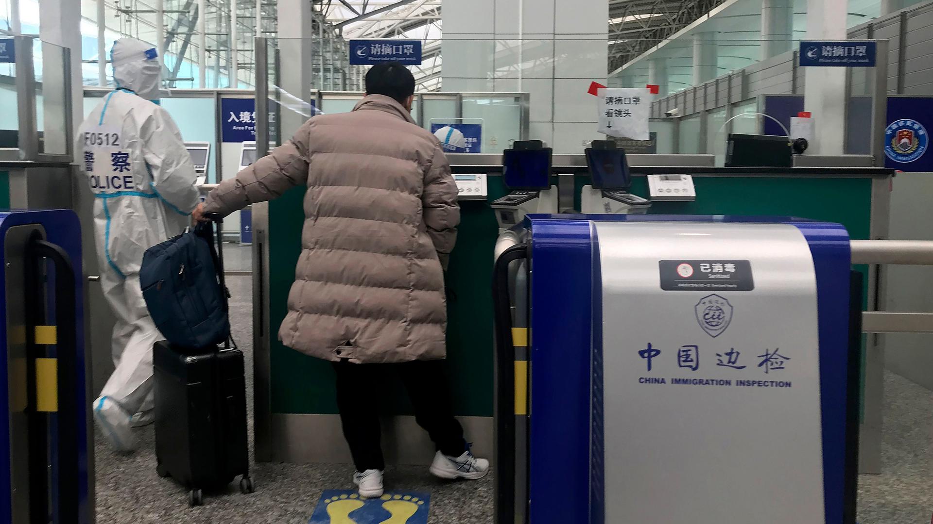 Menschen stehen in China an einem Flughafen-Kontrollgang.