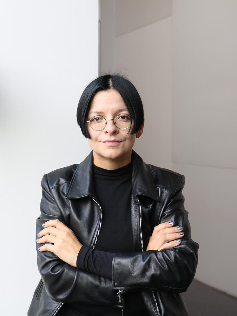 Die Installationskünstlerin Henrike Naumann in schwarzer Lederjacke vor einem ihrer Werke. 
