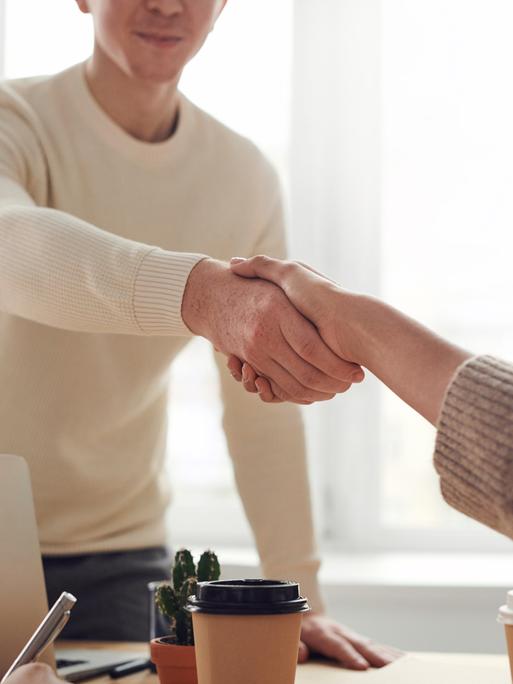 Ein Mann schüttelt einer Frau die Hand. Ein Mann schüttelt einer Frau die Hand.