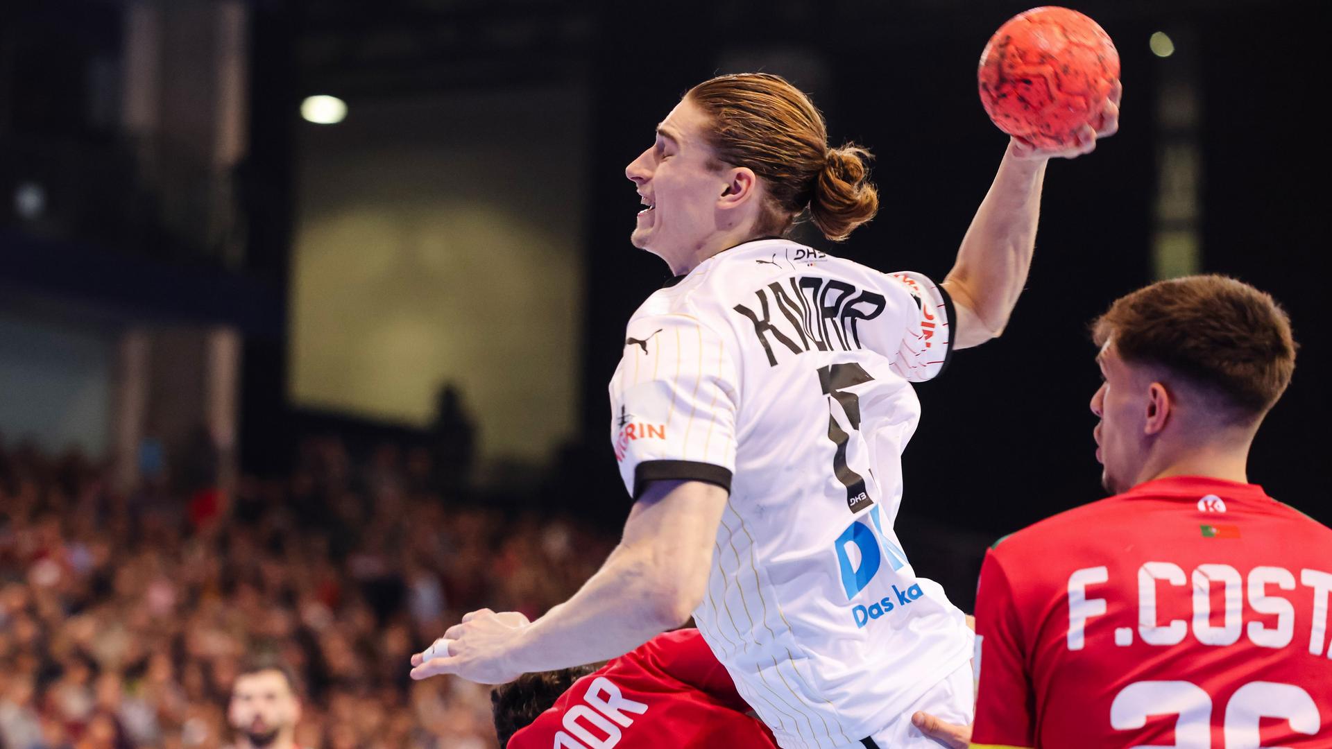 Deutschlands Handball-Nationalspieler Juri Knorr (Mitte) setzt sich gegen Portugals Francisco Costa (rechts) und Salvador Salvador (links) durch.