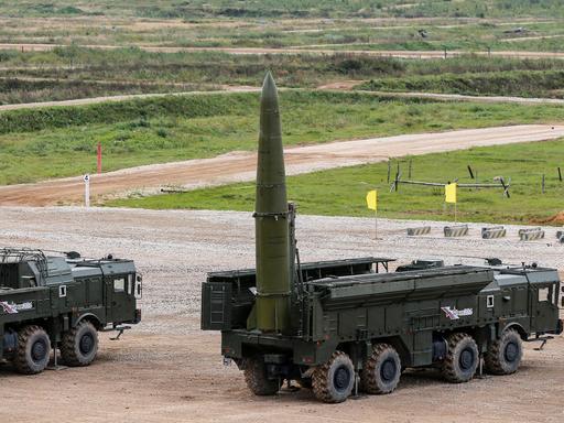 Auf einem Truppenübungsplatz ist eine russische Rakete mit Atomsprengkopf auf einem Militärfahrzeug montiert. Die Rakete zeigt senkrecht in den Himmel, als wäre sie bereit zum Abschuss.