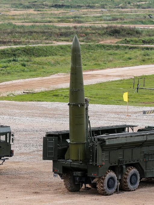 Auf einem Truppenübungsplatz ist eine russische Rakete mit Atomsprengkopf auf einem Militärfahrzeug montiert. Die Rakete zeigt senkrecht in den Himmel, als wäre sie bereit zum Abschuss.