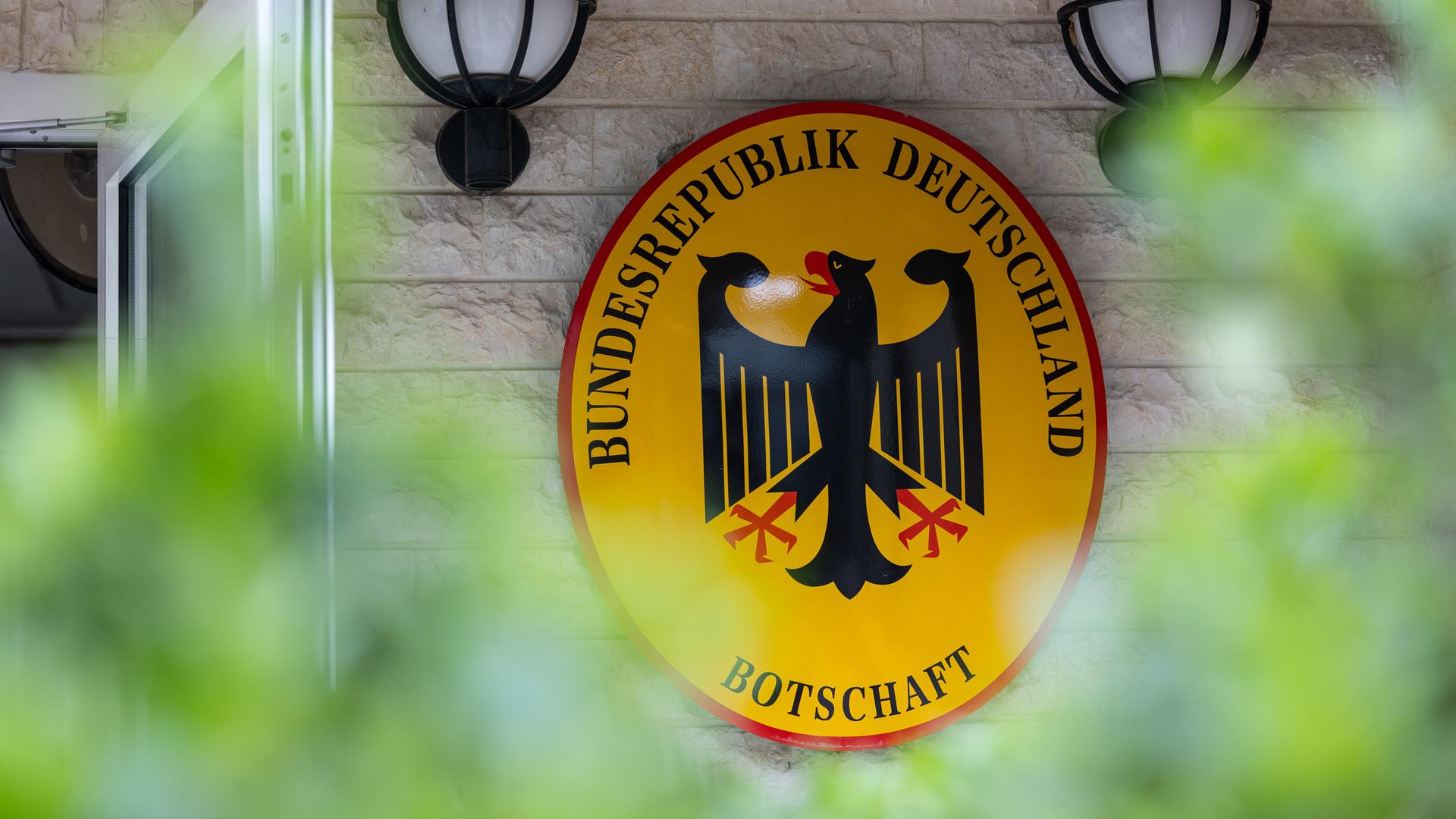Blick auf ein Schild mit Bundesadler und dem Schriftzug "Bundesrepublik Deutschland Botschaft"