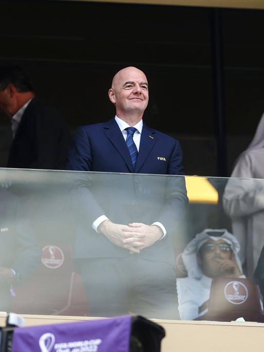 FIFA-Präsident Gianni Infantino bei dem WM in Katar auf der Tribüne. Neben ihm stehen saudische Offizielle. 