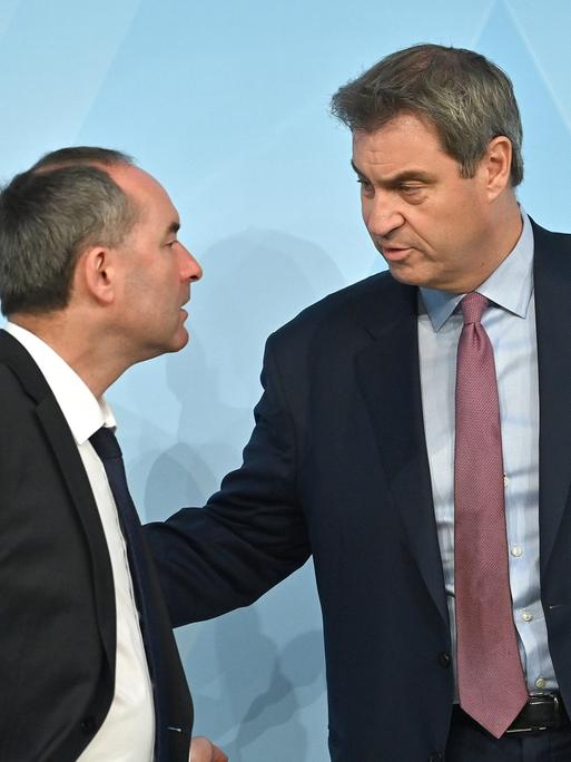 Bayerns Wirtschaftsminister Hubert Aiwanger blickt zu Ministerpräsident Markus Söder, dieser schaut ihn ernst an.