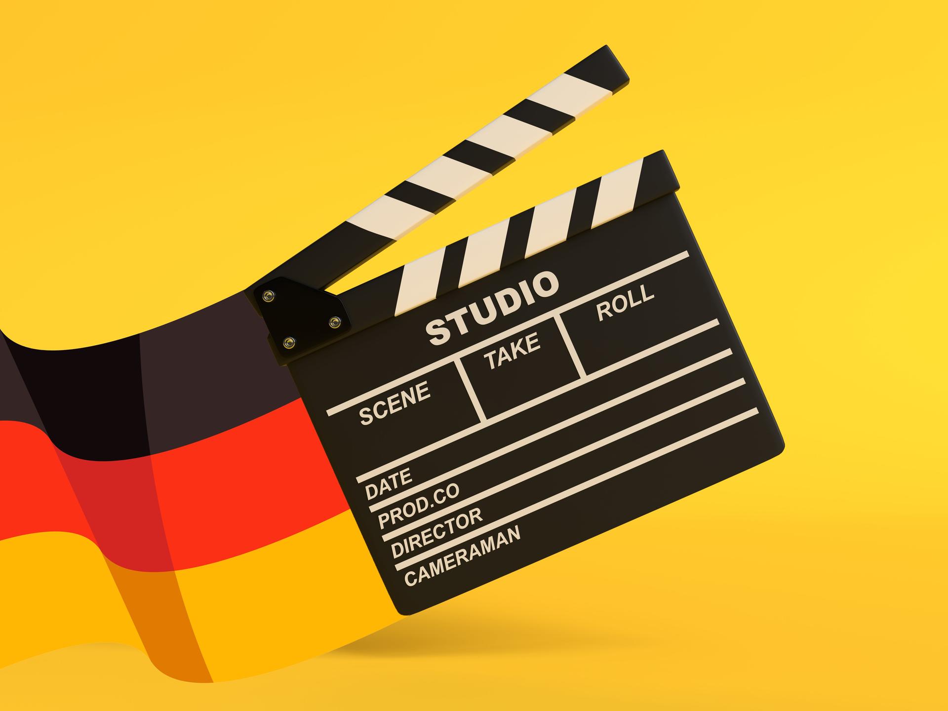 Illustration einer Filmklappe vor gelben Hintergrund. Links am Bildrand weht eine deutsche Flagge.