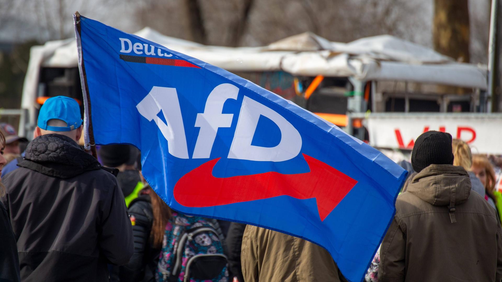 Bei einer Demonstration ist eine Fahne mit dem Logo der Partei "Alternative für Deutschland" (AfD) zu sehen. 