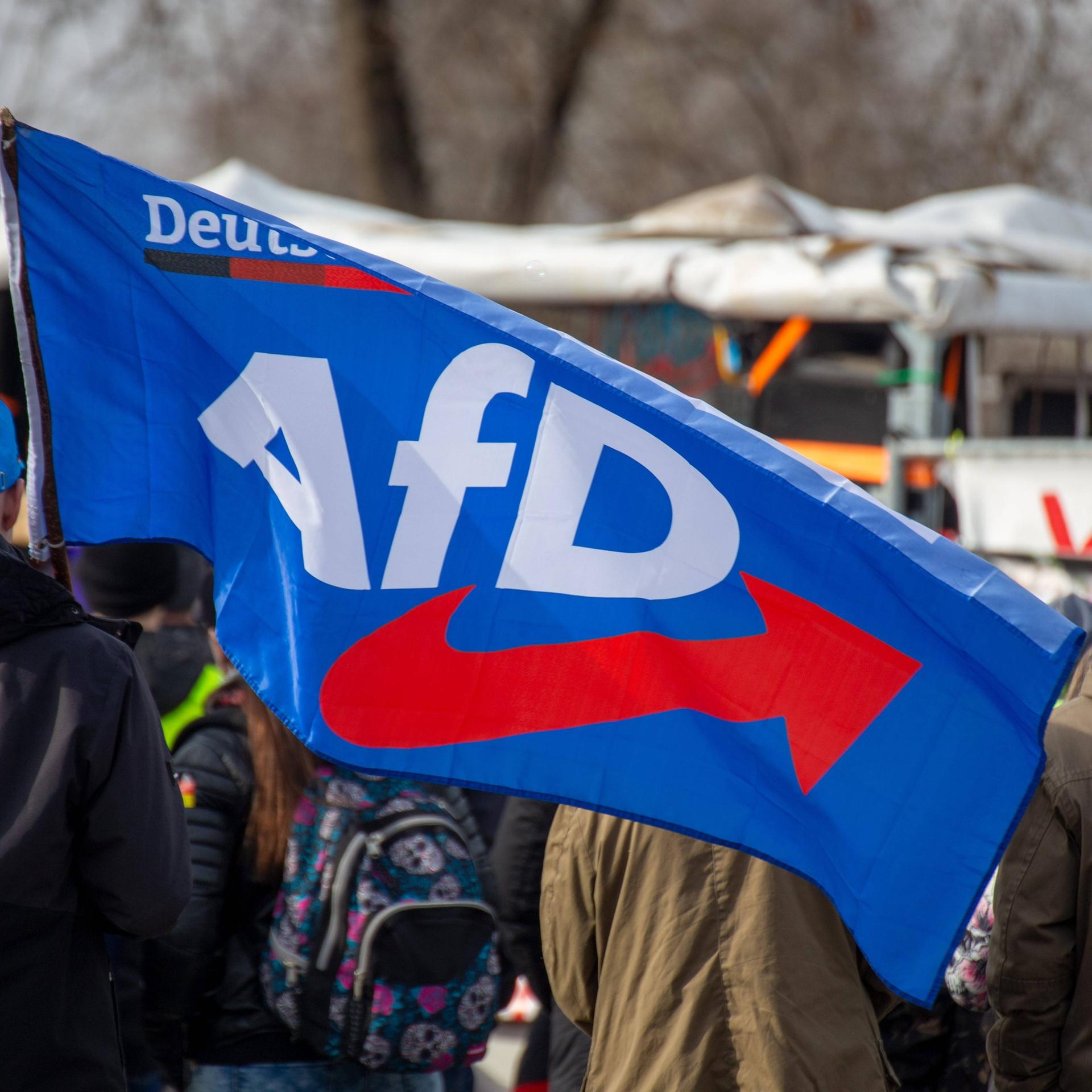 Bei einer Demonstration ist eine Fahne mit dem Logo der "Alternative für Deutschland" (AfD) zu sehen. 