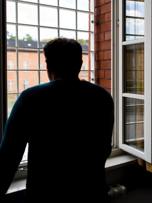 Ein Straftäter steht vor einem vergitterten Fenster in der Klinik für Forensische Psychiatrie (Maßregelvollzug) auf dem Gelände des Martin Gropius Krankenhauses in Eberswalde (Brandenburg) Ein Straftäter steht vor einem vergitterten Fenster in der Klinik für Forensische Psychiatrie (Maßregelvollzug) auf dem Gelände des Martin Gropius Krankenhauses in Eberswalde (Brandenburg)