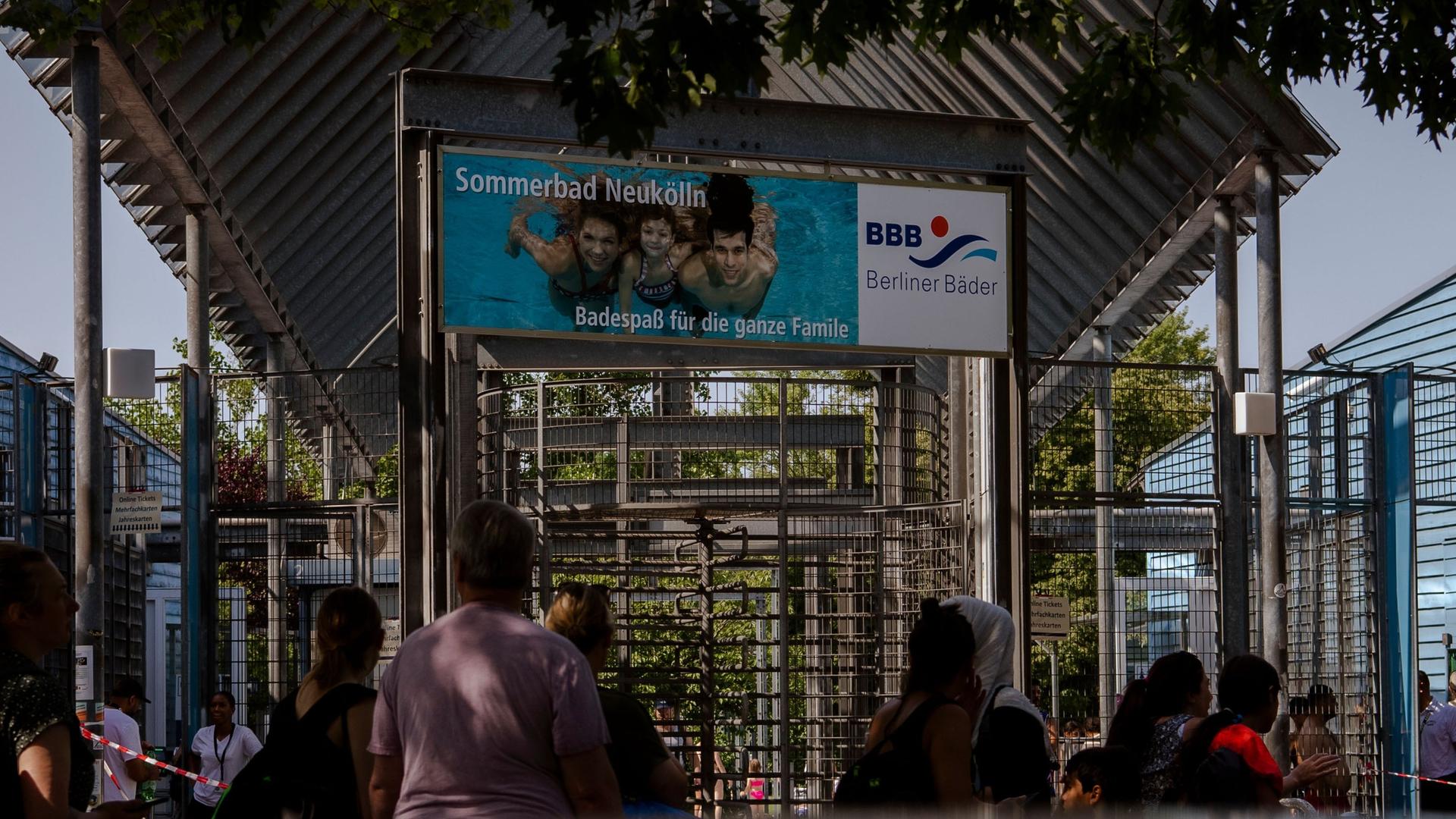 Zahlreiche Menschen stehen an dem Eingang des Sommerbades Neukölln am Columbiadamm. Zahlreiche Menschen stehen an dem Eingang des Sommerbades Neukölln am Columbiadamm.