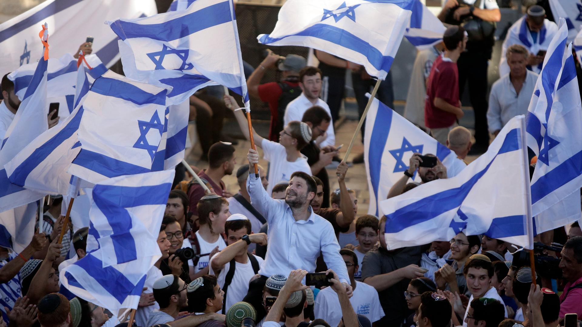 Mitglieder der israelischen Knesset: Finanzminister Bezalel Smotrich winkt zusammen mit anderen ultranationalistischen Mitgliedern mit Flaggen anlässlich des "Jerusalem Flag March".

