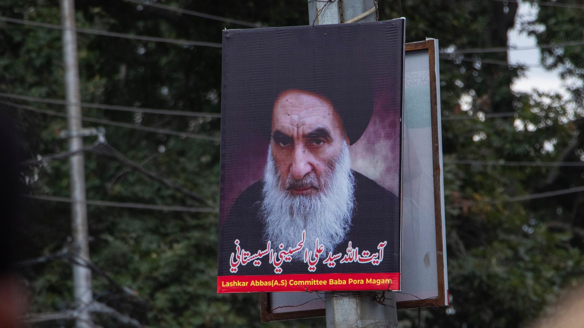Ein Plakat des geistlichen Oberhauptes der Schiiten im Irak, Ayatollah Sistani, ist an einem Laternenpfahl befestigt.