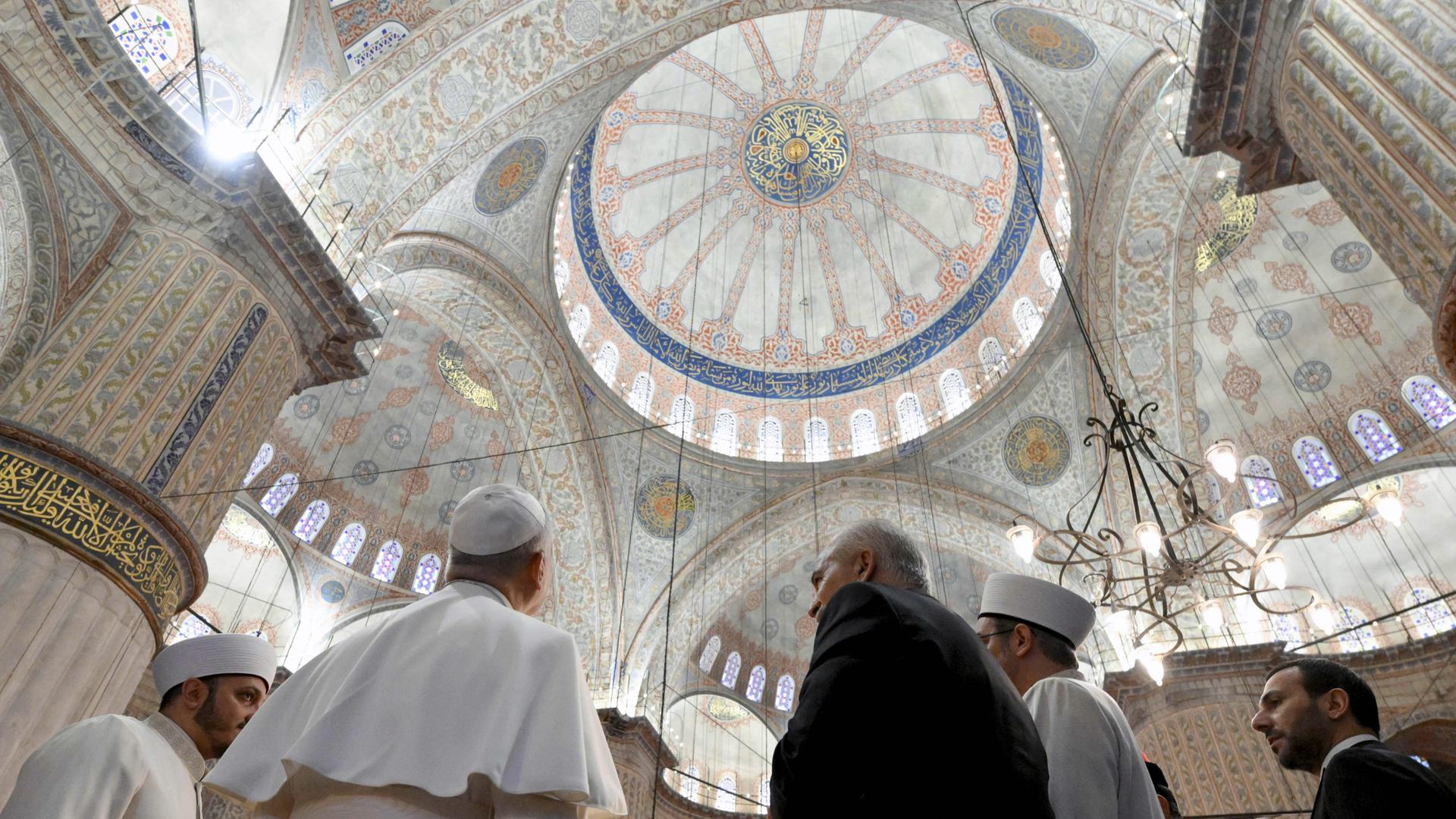 Papst Leo steht mit dem Rücken zur Kamera. Er schaut sich die Kuppel von der Blauen Moschee in Istanbul an. Papst Leo steht mit dem Rücken zur Kamera. Er schaut sich die Kuppel von der Blauen Moschee in Istanbul an.