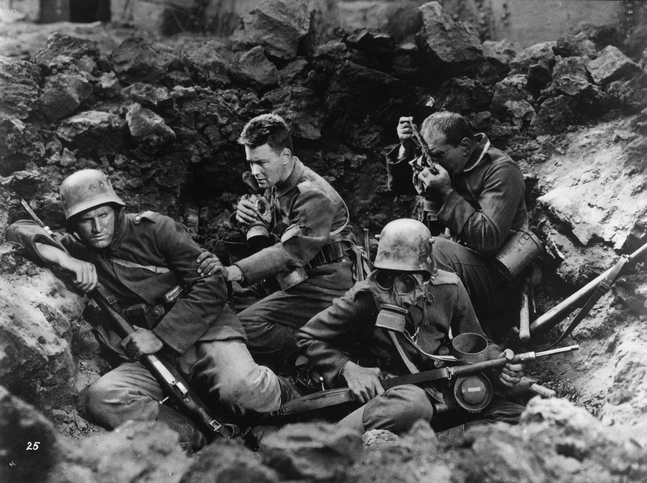 Szene aus dem Antikriegsfilm „Im Westen nichts Neues“ von 1929. Mehrere Soldaten liegen in einem Schützengraben.  