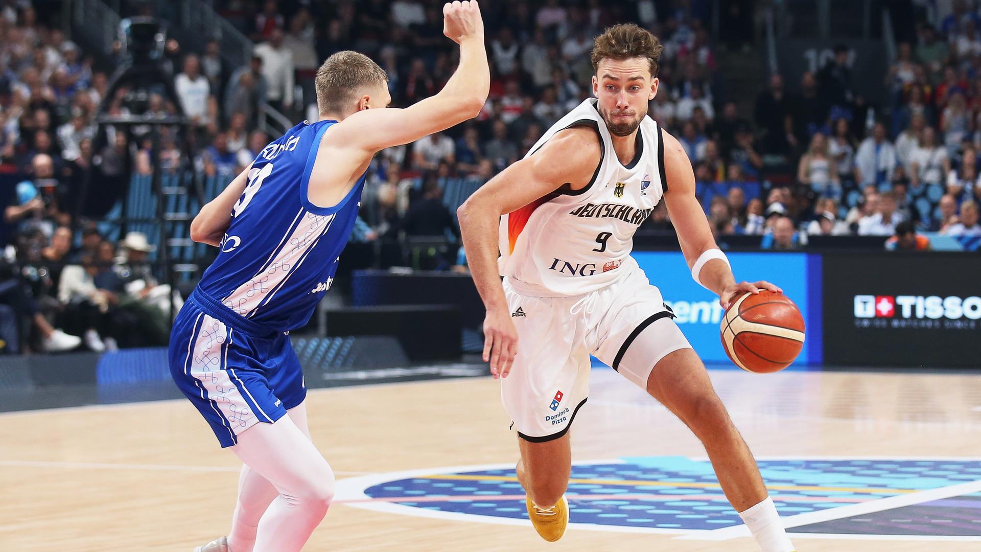 Der deutsche Basketball-Nationalspieler Franz Wagner dribbelt den Ball und wird von einem Gegenspieler verteidigt. Der deutsche Basketball-Nationalspieler Franz Wagner dribbelt den Ball und wird von einem Gegenspieler verteidigt.