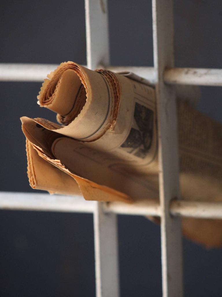 Eine Zeitung steckt in einem Gitter.