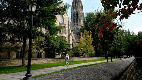 Blick auf den Yale-Campus: im Hintergrund eine Kirche, im Vordergrund eine Person, die auf dem Gehsteig läuft.