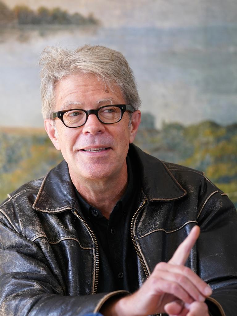 US-Schriftsteller Jonathan Franzen spricht während einer Pressekonferenz in Lübeck. Er blickt zur Seite und hat einen Zeigefinger erhoben.