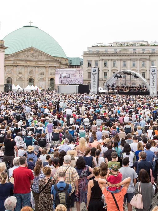 Blick auf den Bebelplatz in Berlin, wo viele Menschen einem Konzert zuhören